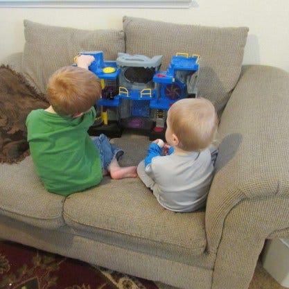 little boys on couch with Batcave