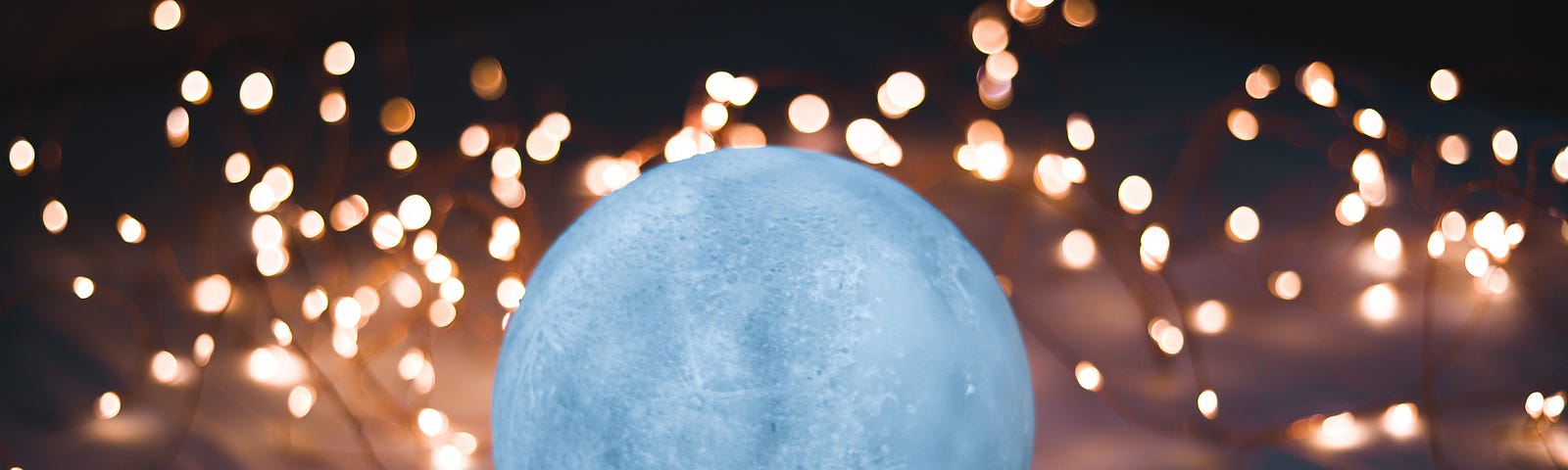 A glowing globe set on top of a cloth on a table with little dotted lights surrounding it as if it were the moon, but used to also show the depth of glow pertinent to the Mysterious Egg in this story.