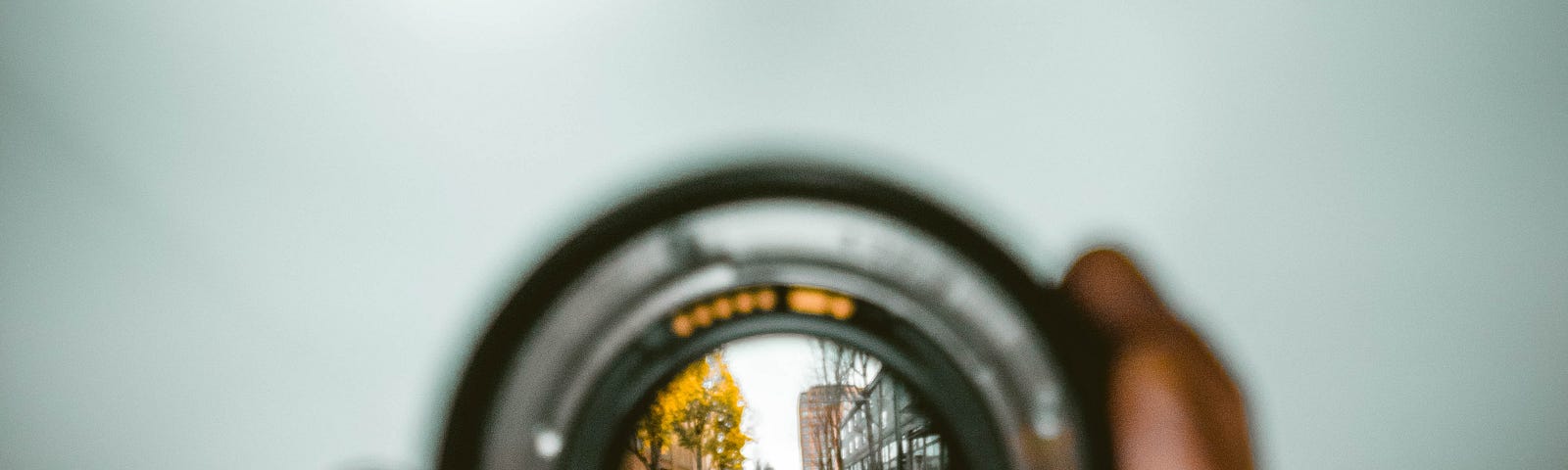 Hand holding camera lens to focus.