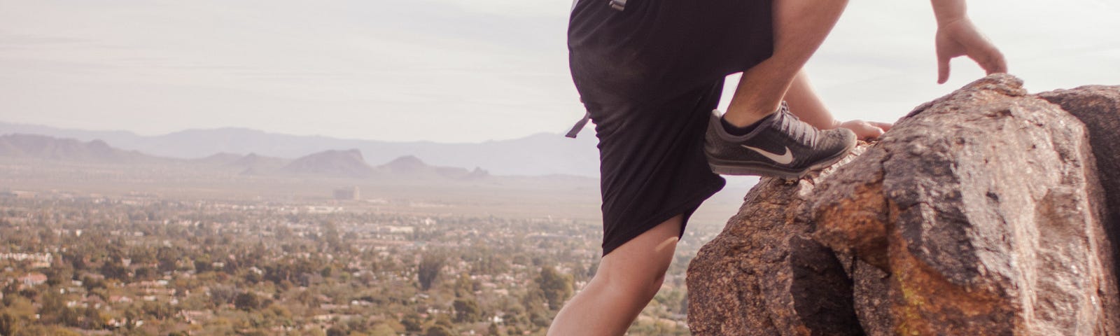 A teenage climbing big boulders.