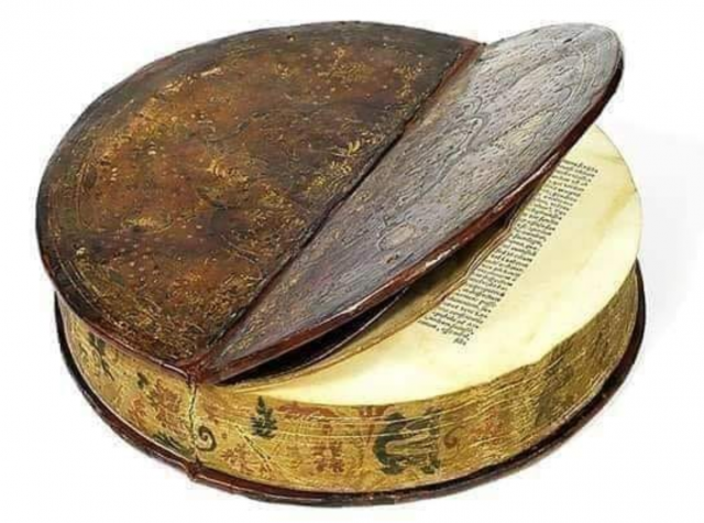 a book that is round, looks very old, cover splits along the diameter and you can see half of the pages through it.
