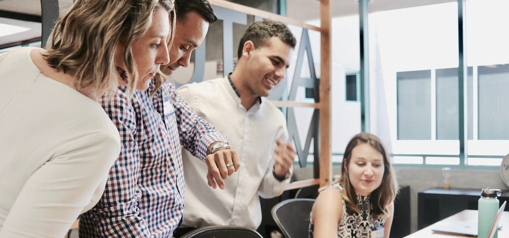 two ladies and two men standing in a conference room.