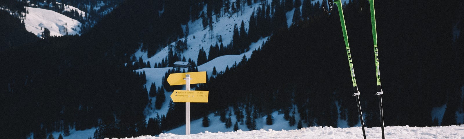 Skis and poles at the stop of a snowy hill