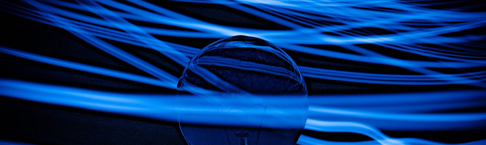A light bulb extends from the bottom of the image. There are blue strands of light coursing horizontally across the entire image, one in front of the bulb, the rest behind it.