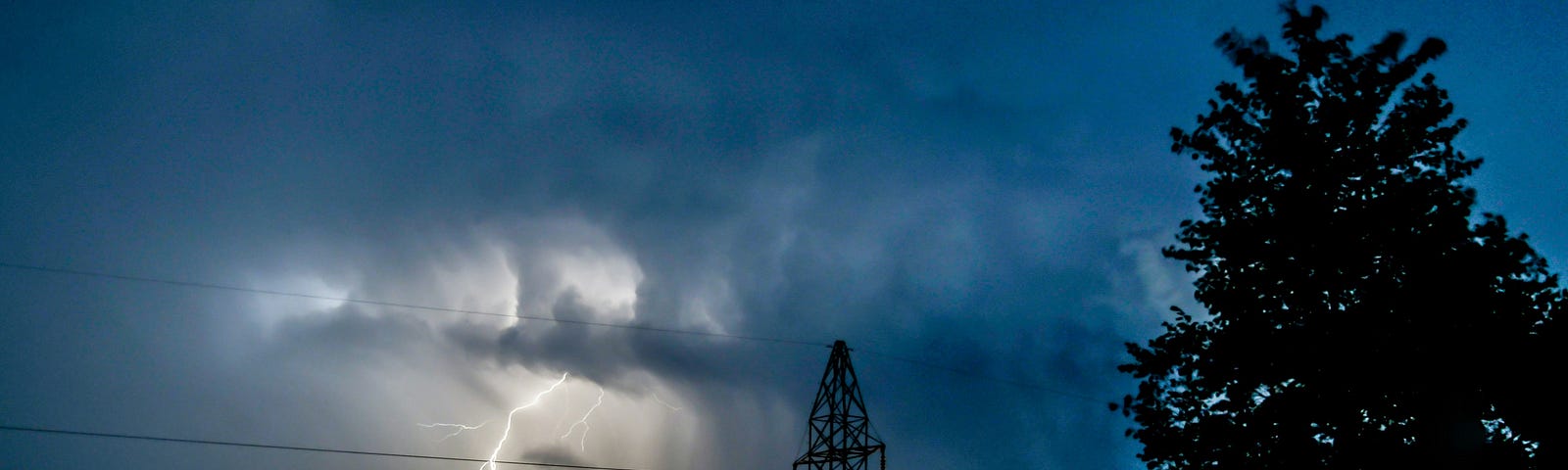 A lightning flash next to a power line.