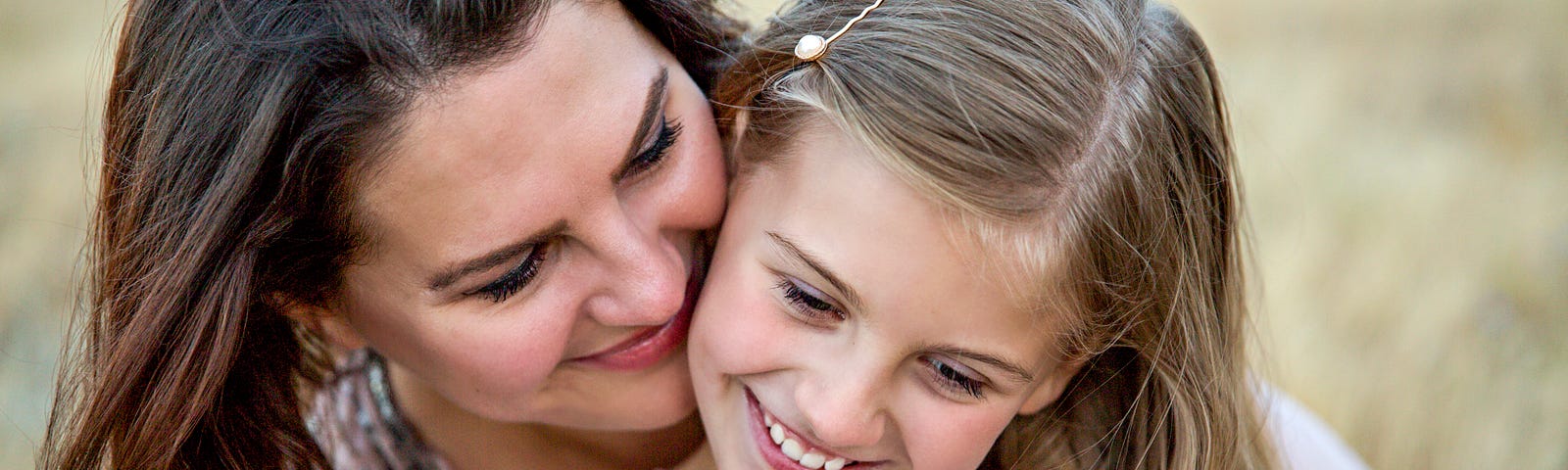 Smiling woman embracing a smiling child
