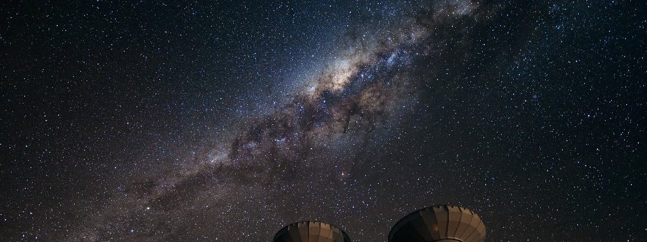 Four of the first ALMA antennas at the Array Operations Site (AOS), located at 5000 meters altitude on the Chajnantor plateau, in the II Region of Chile, with the Milky Way in the background.