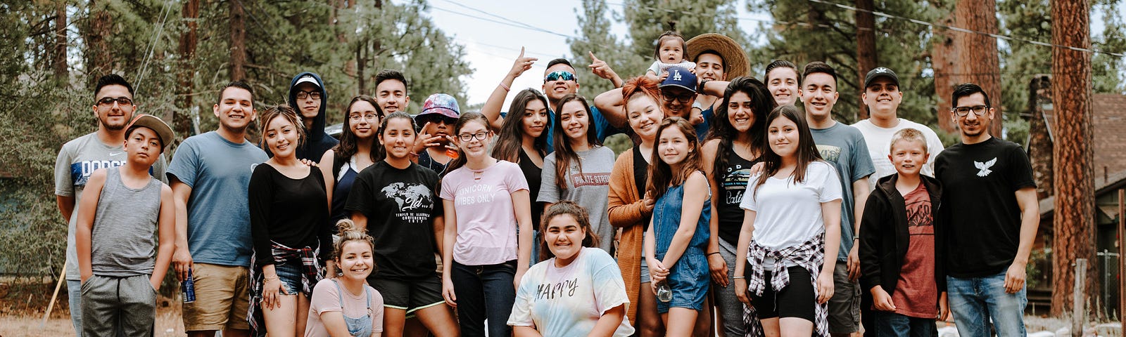 A group of people standing in front of trees.