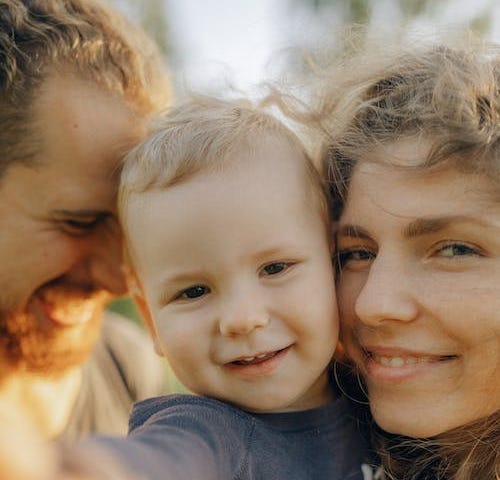 Smiling parents with their adorable child.