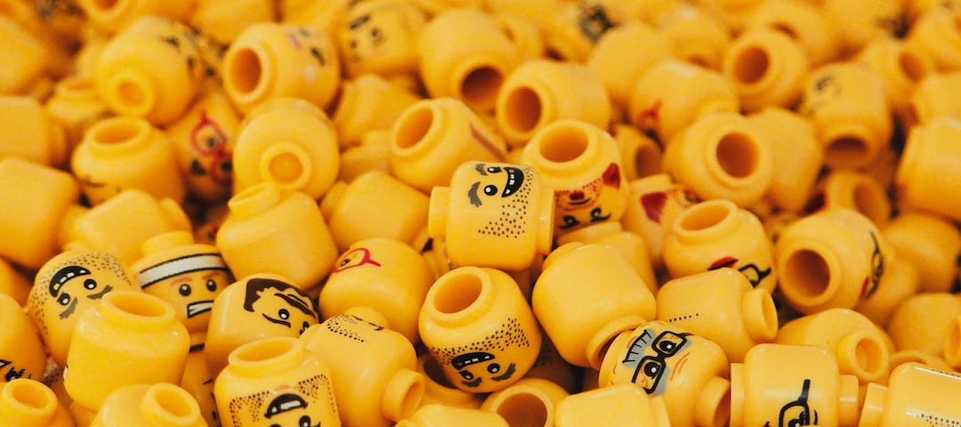 A pile of Lego heads. Standard shape, size and colour. Different little faces though.