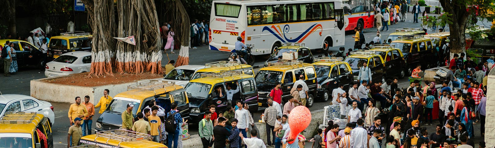 Bustling Mumbai city with traffic — cabs, buses and people milling around