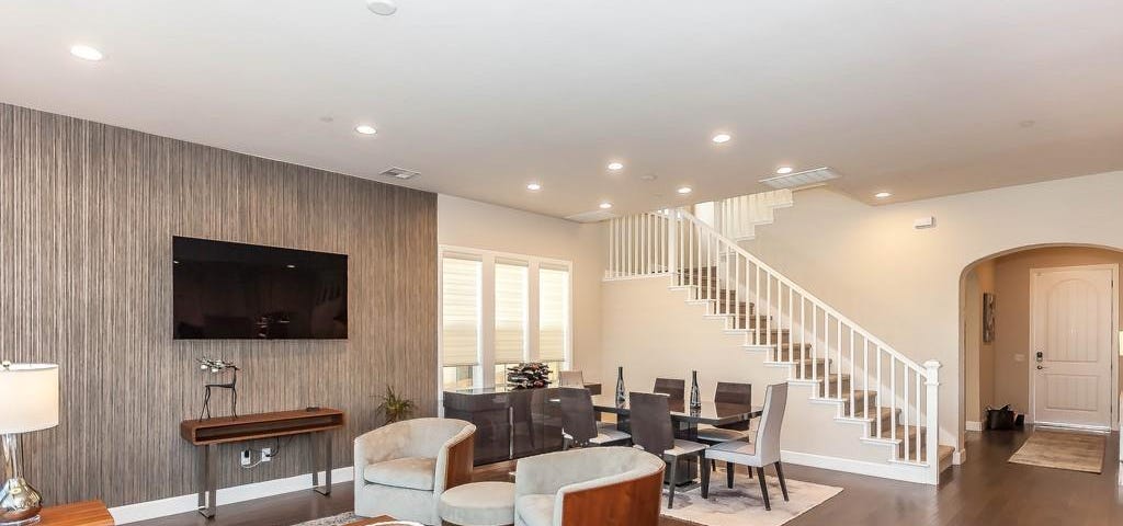 Living room with gray sofa set, hardwood floor and beige interior paint