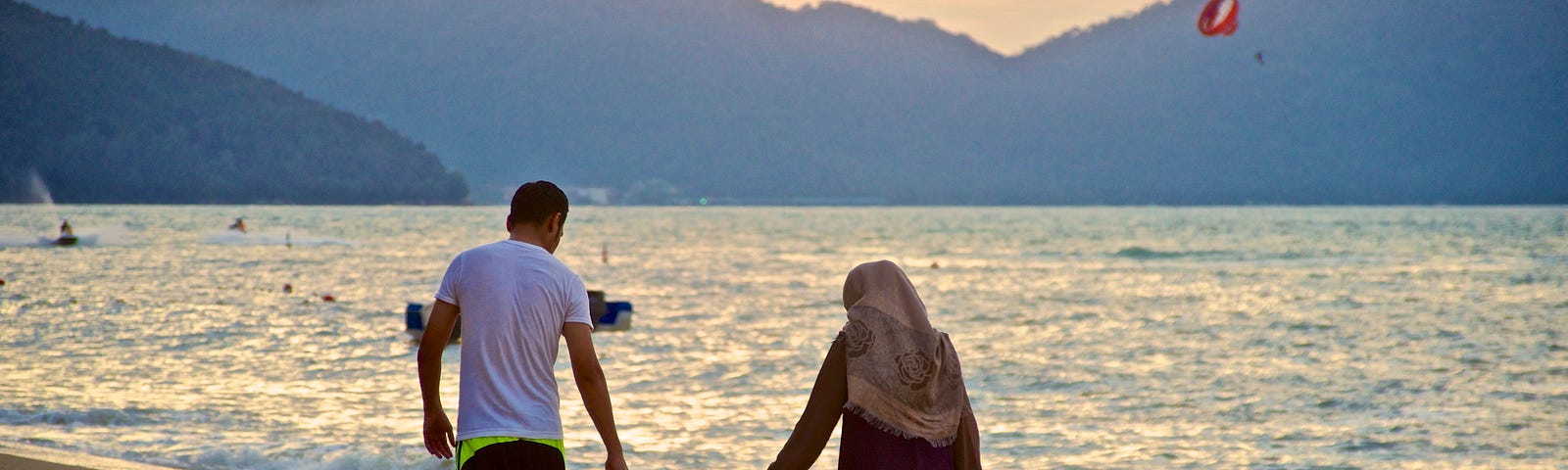 A Muslim family walking on the beach.