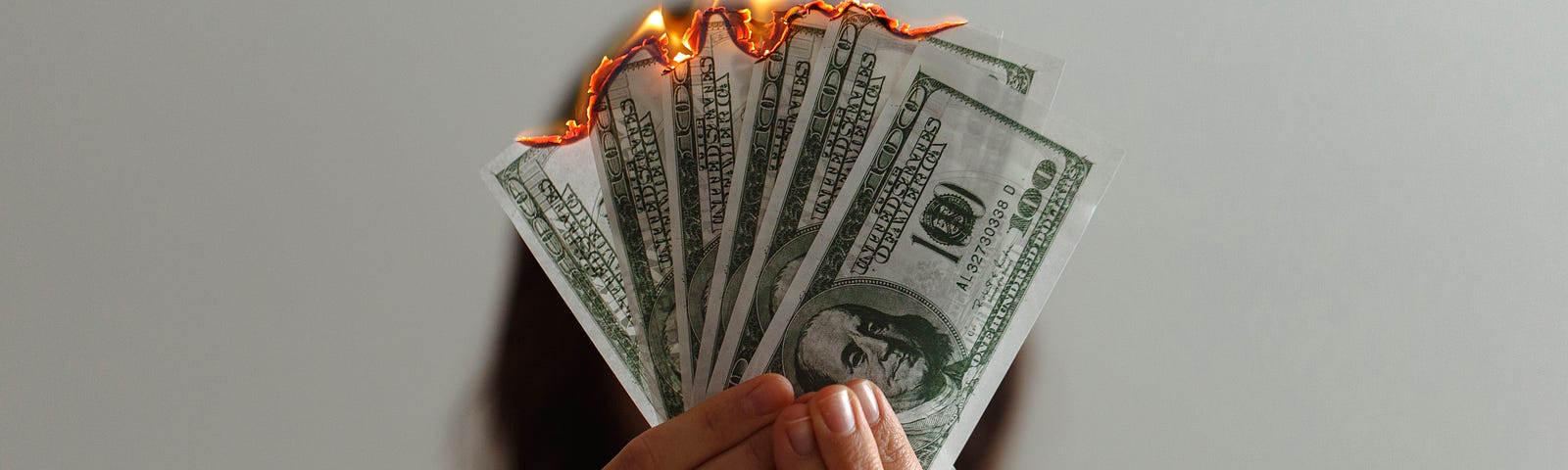 This shows a woman holding money that’s on fire.