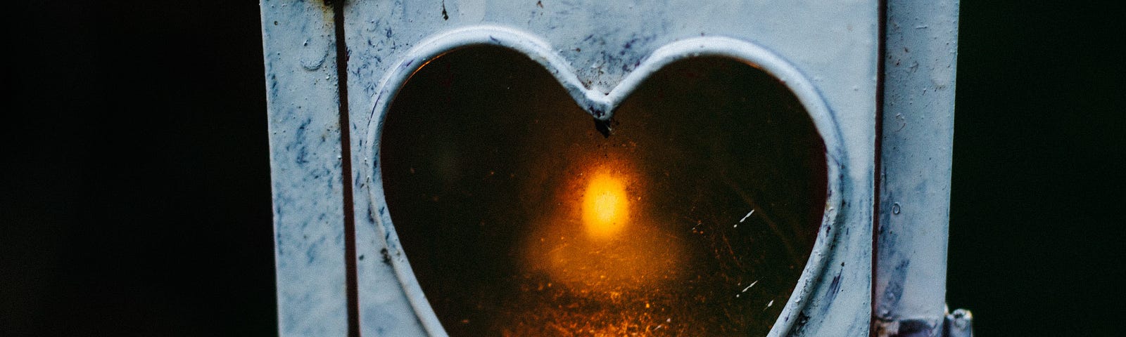 candle burning in a lantern with heart shaped glass, love, longing, relationship, growth, pain, joy, believing