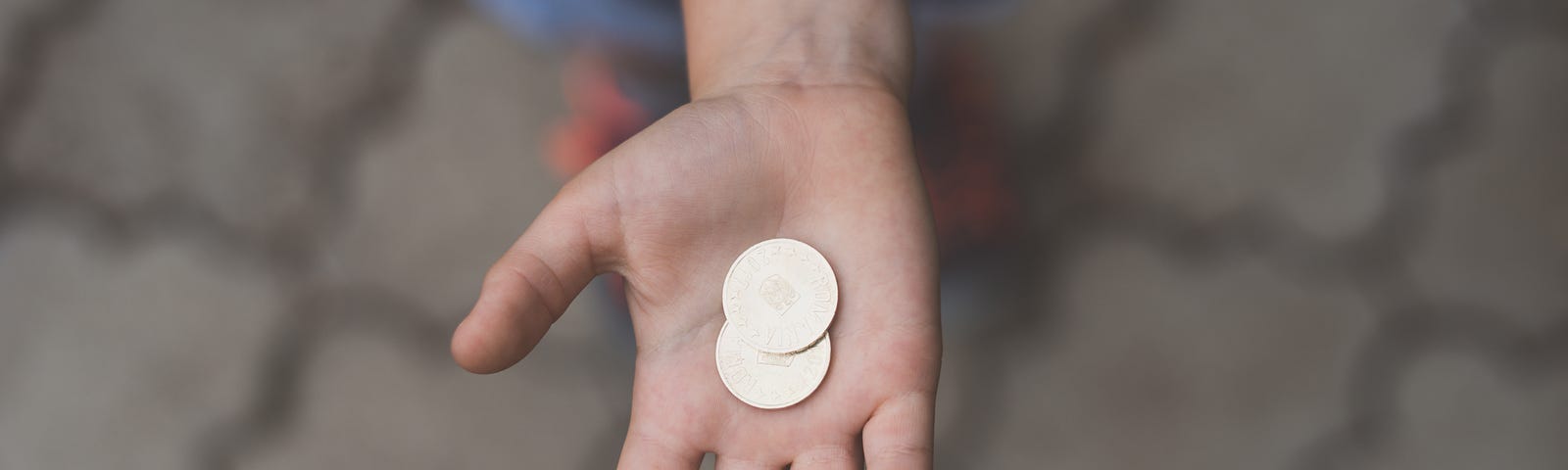 Hand holding two coins in its palm