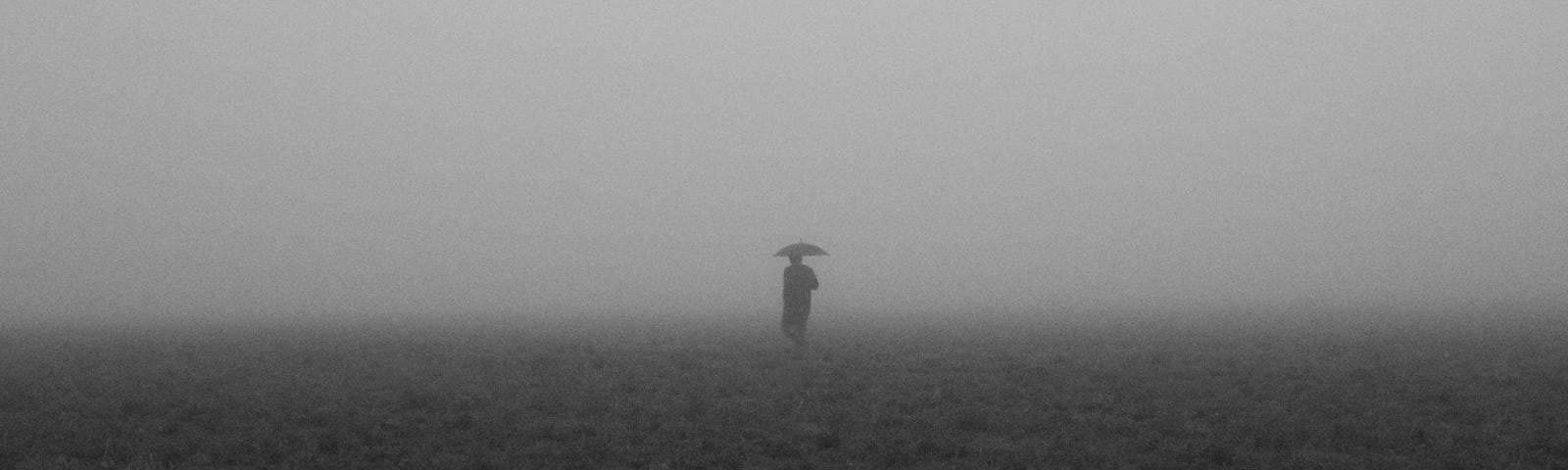 a person standing in the rain with an umbrella