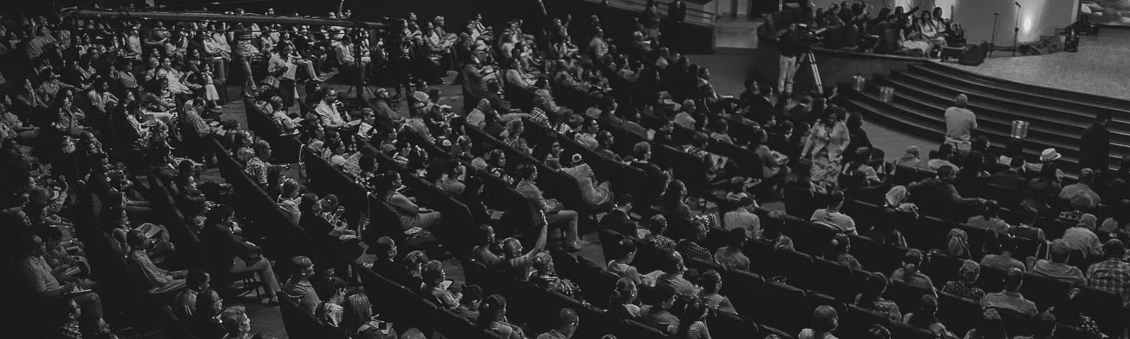 A black-and-white image of a theater audience.