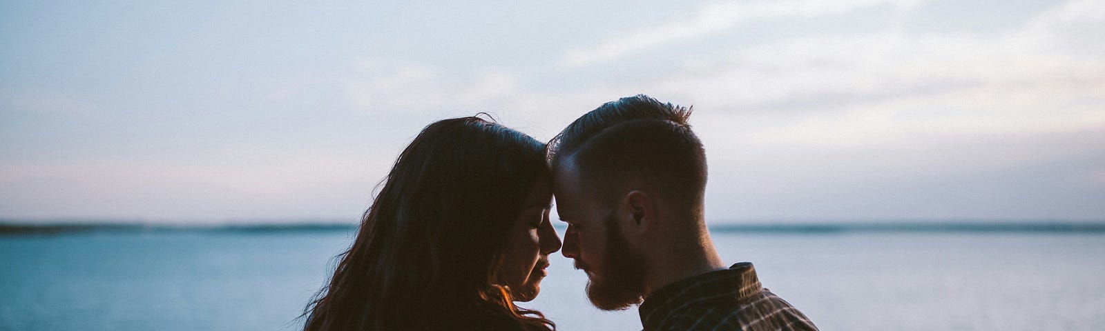 A woman and a man being intimate with their heads together