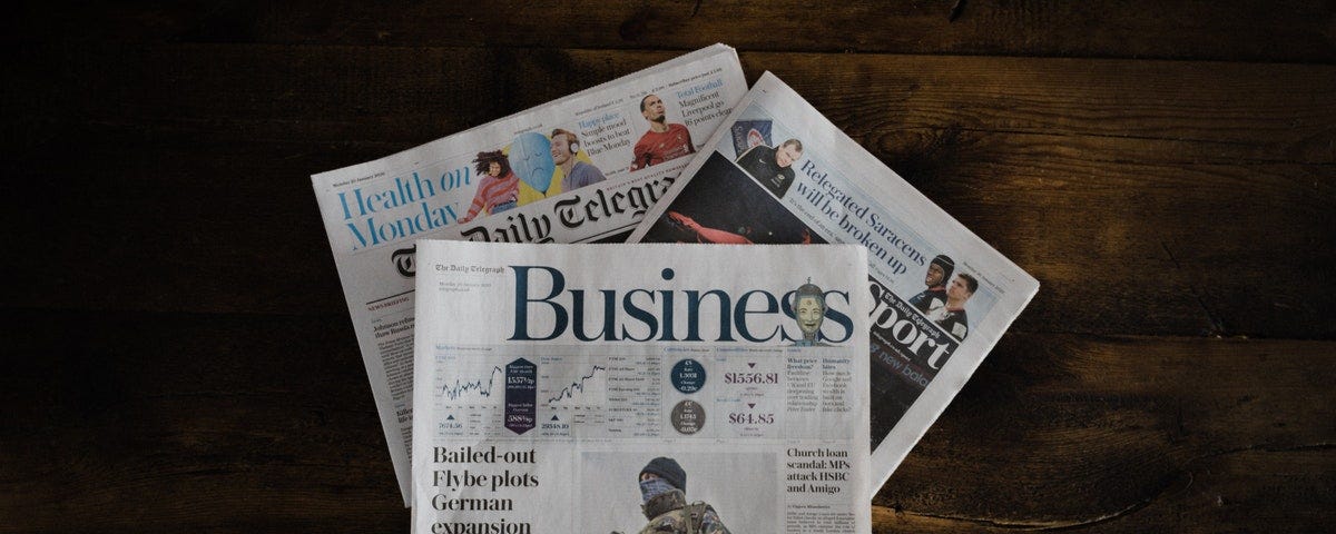 A stack of newspapers on a wooden table.