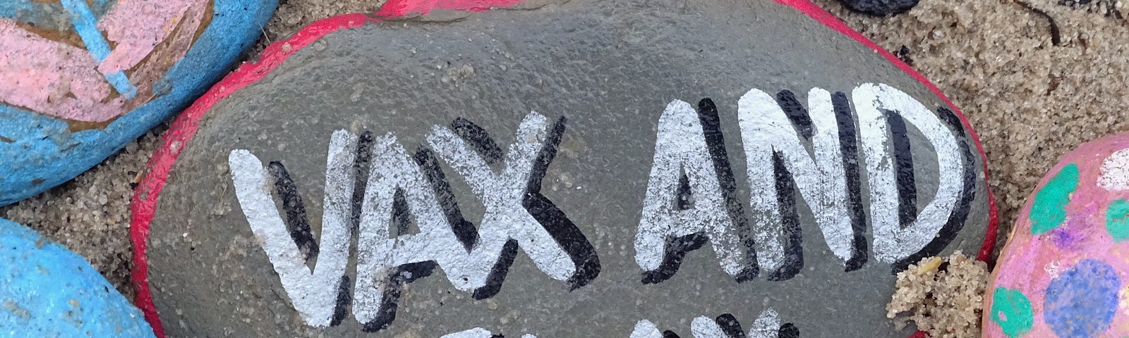 A pile of stones. On the centre one is written “Vax and Relax.”