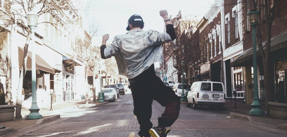 Man in the road doing a celebratory heel-click jump.