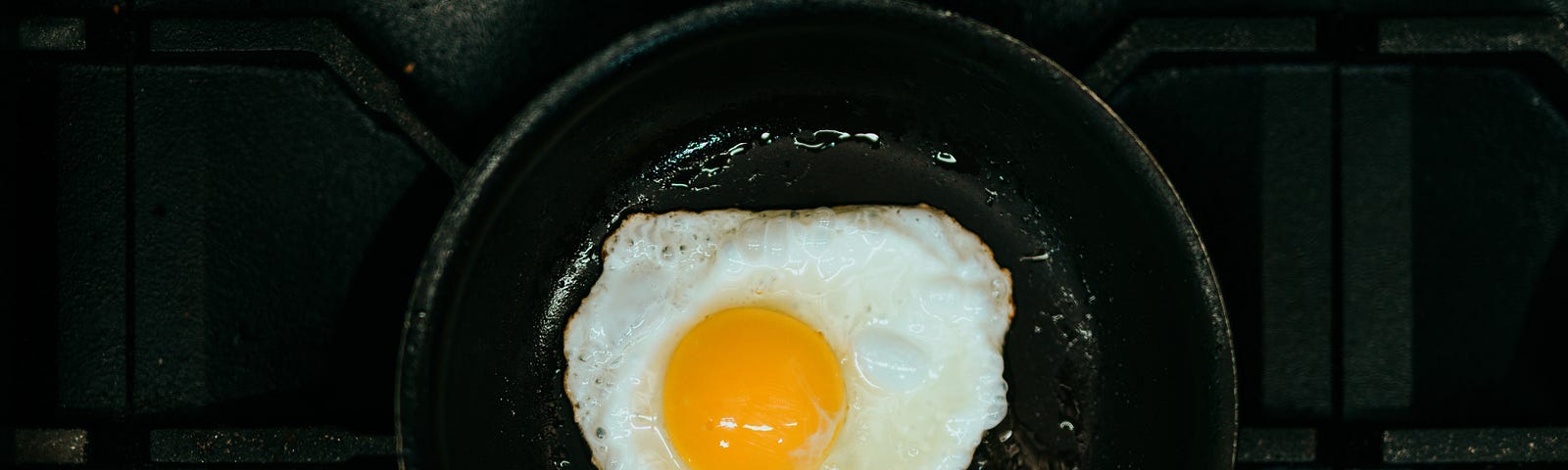 A sunny-side-up egg in a frying pan.