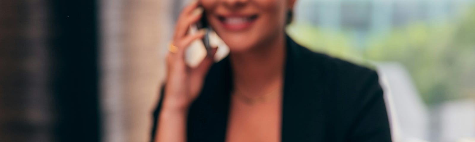 woman on a phone sitting at a desk