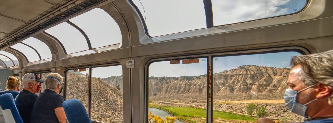 Passengers looking out the window on a train.