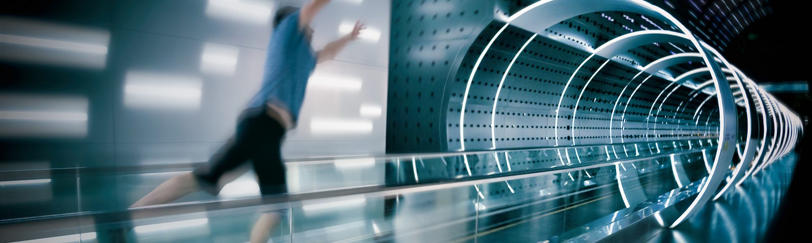 A man jumping forward towards a space age looking tunnel