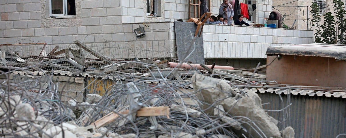 Los palestinos observan los escombros dejados después de que las fuerzas israelíes demolieron los edificios de propiedad palestina el 18 de octubre de 2018. (Foto: WAFA)