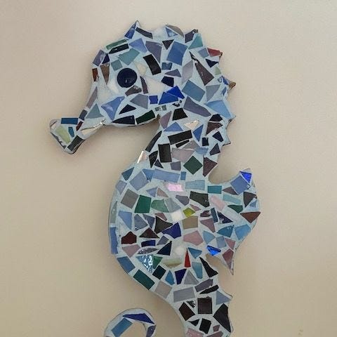 Photo of a seahorse mosaic, filled with blue and green glass tiles