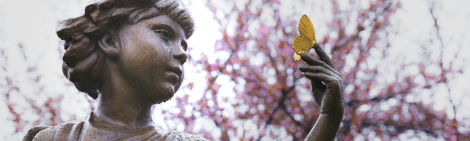 A statue holding a yellow butterfly.