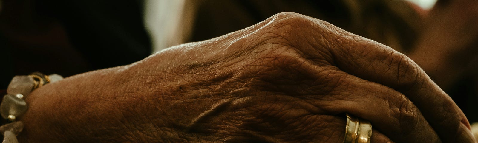 Close up of an elderly women’s hand showing what appears to be a wedding band.