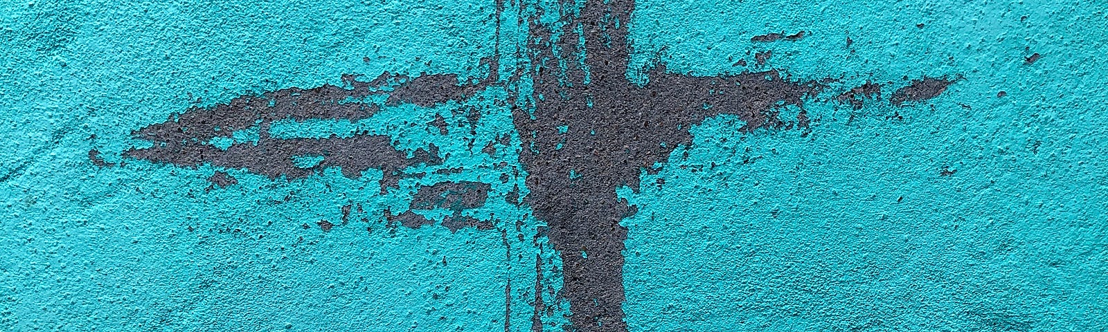 Red painted cross against a blue background