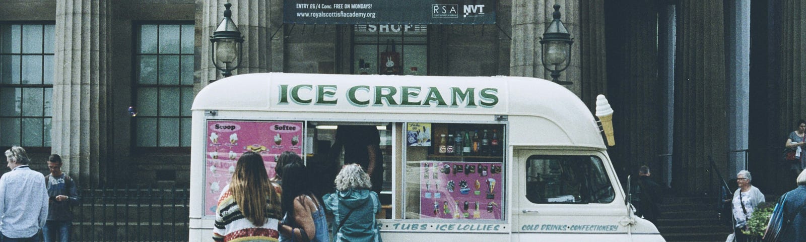 a tiny icecream van, with a line up of people waiting