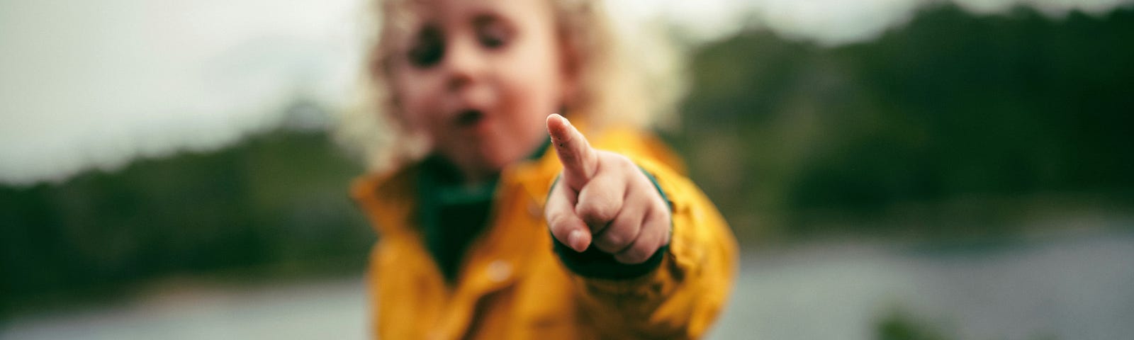 Child pointing something out with their index finger towards the camera.