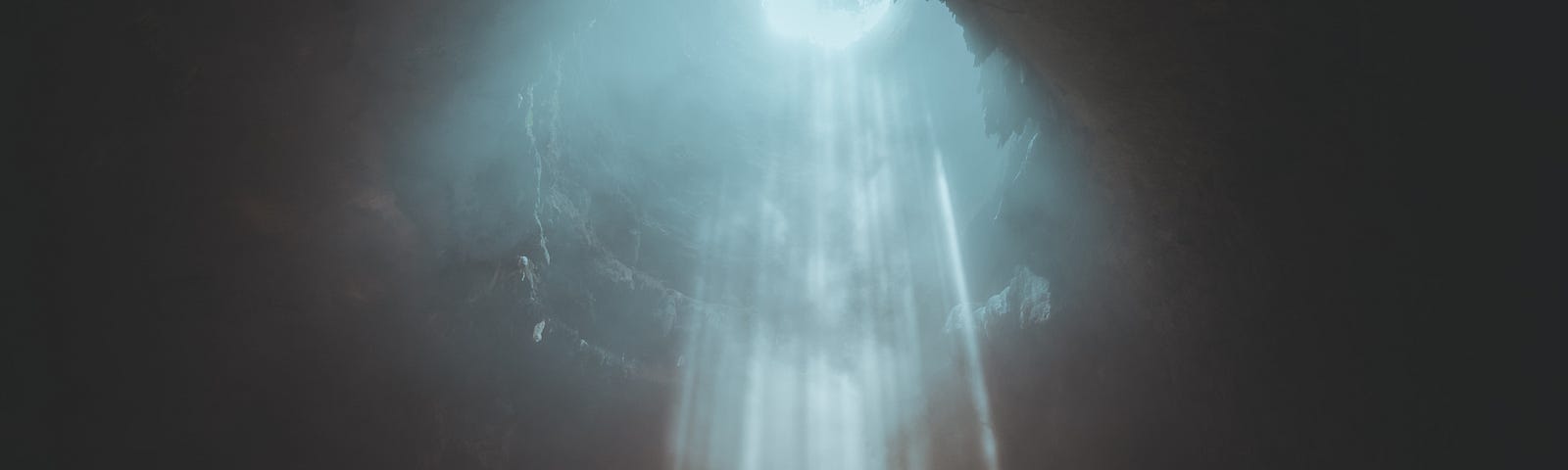 Light shining down from above into a cave.