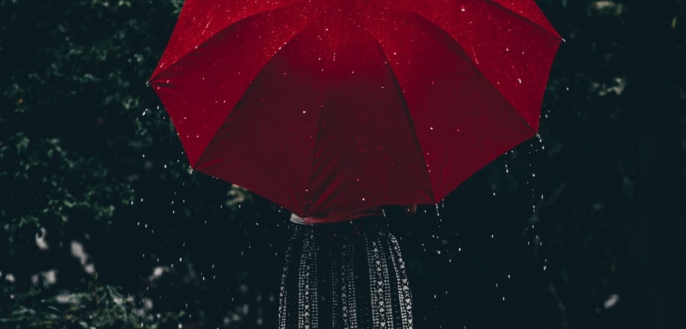 Girl with a red umbrella on a rainy day