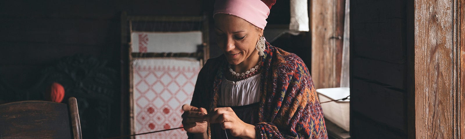 A jeweler making beaded necklaces by hand.