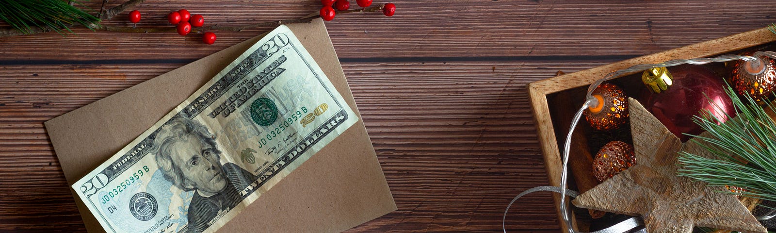 This photo shows a twenty dollar bill next to some Christmas decorations.