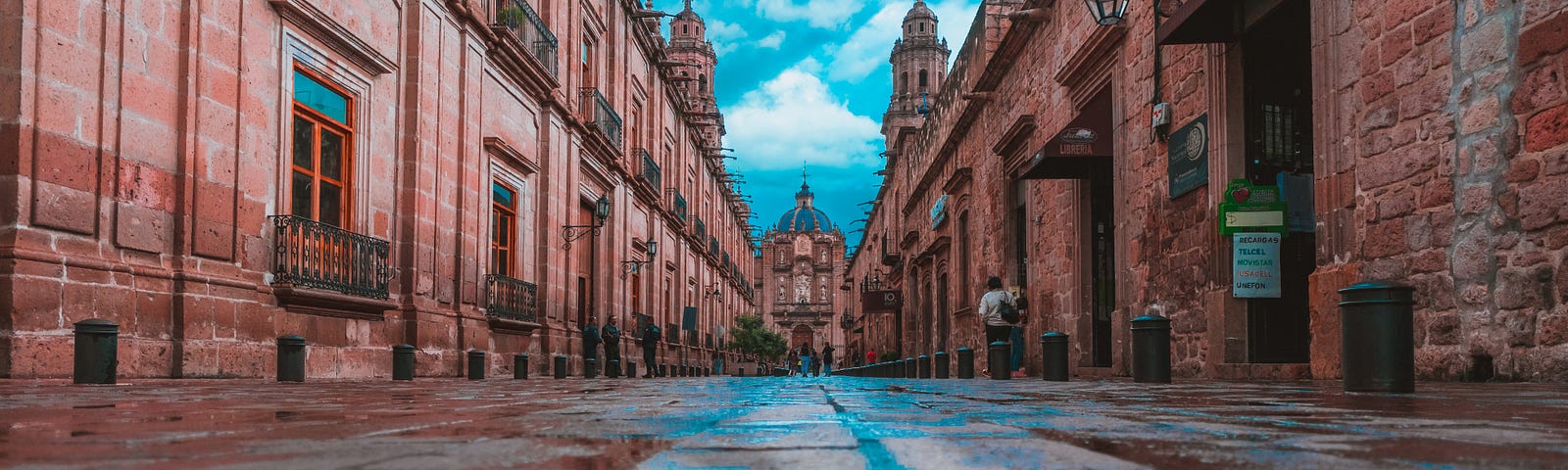 Wet Mexican street reflecting the beautiful buildings above it