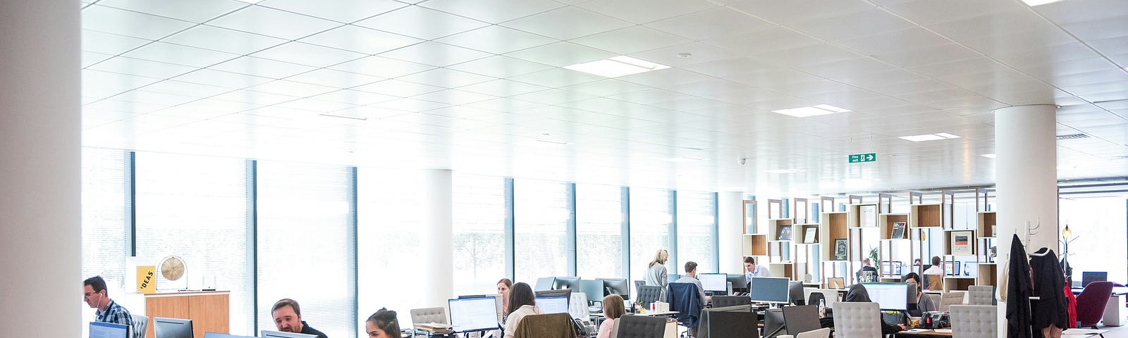 A photo shows a modern corporate workplace with employees working behind desks