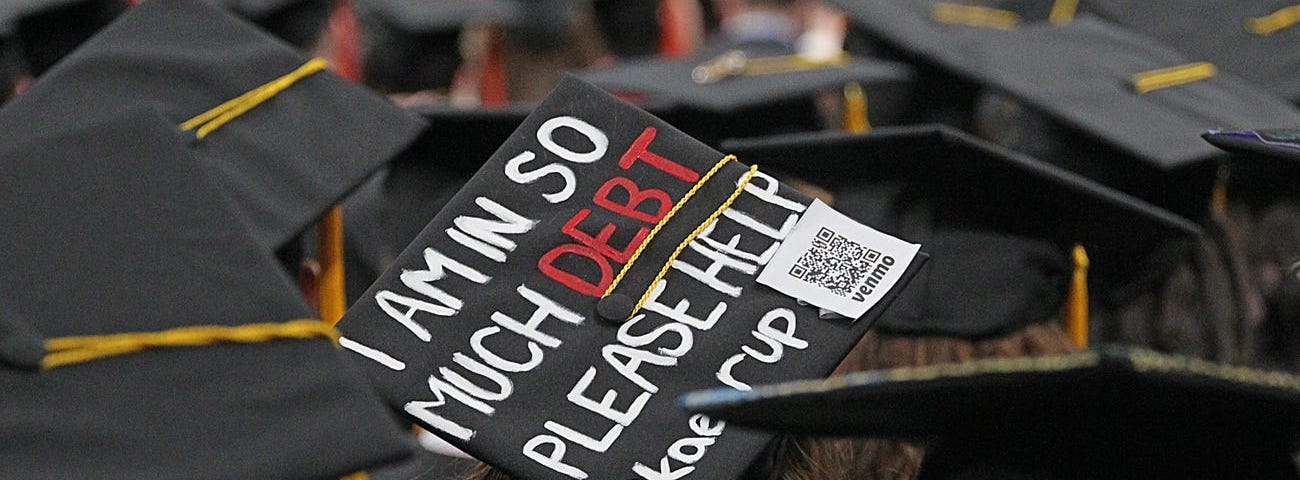 A graduation cap that reads “I am in so much debt please help.”