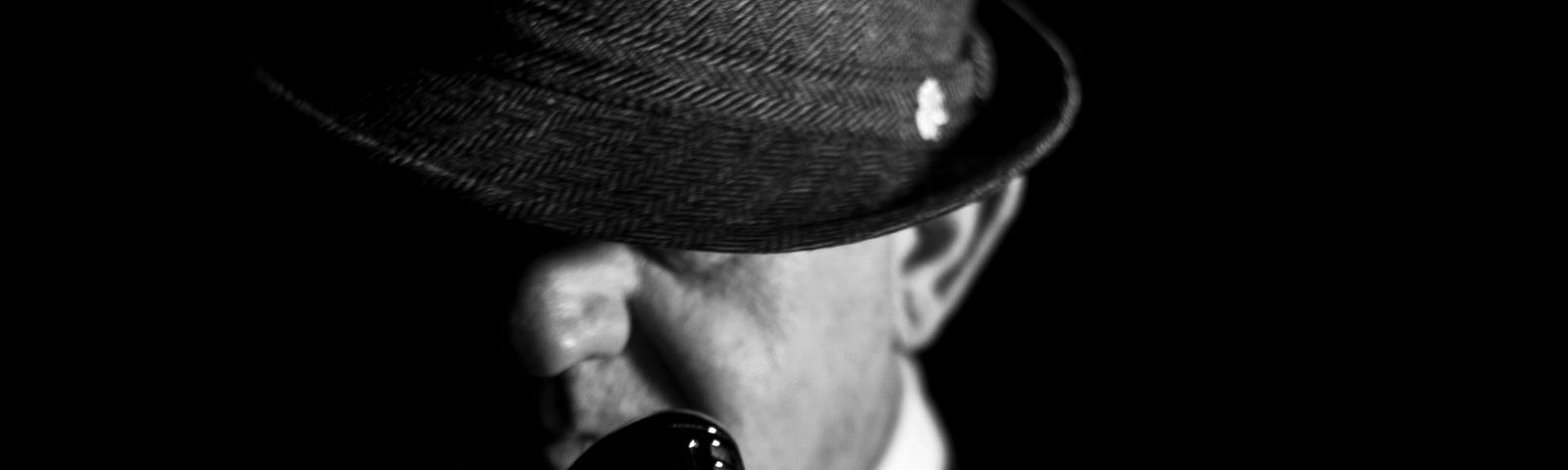 Black and white photograph of man in a fedora hat