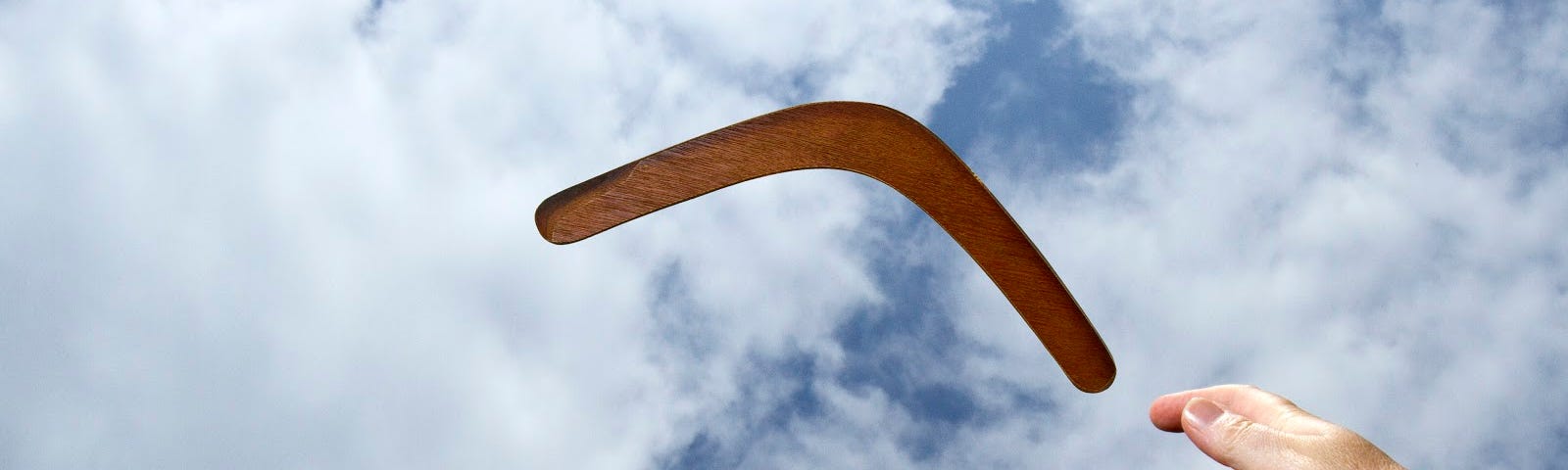 Photo of person tossing a boomerang through the air