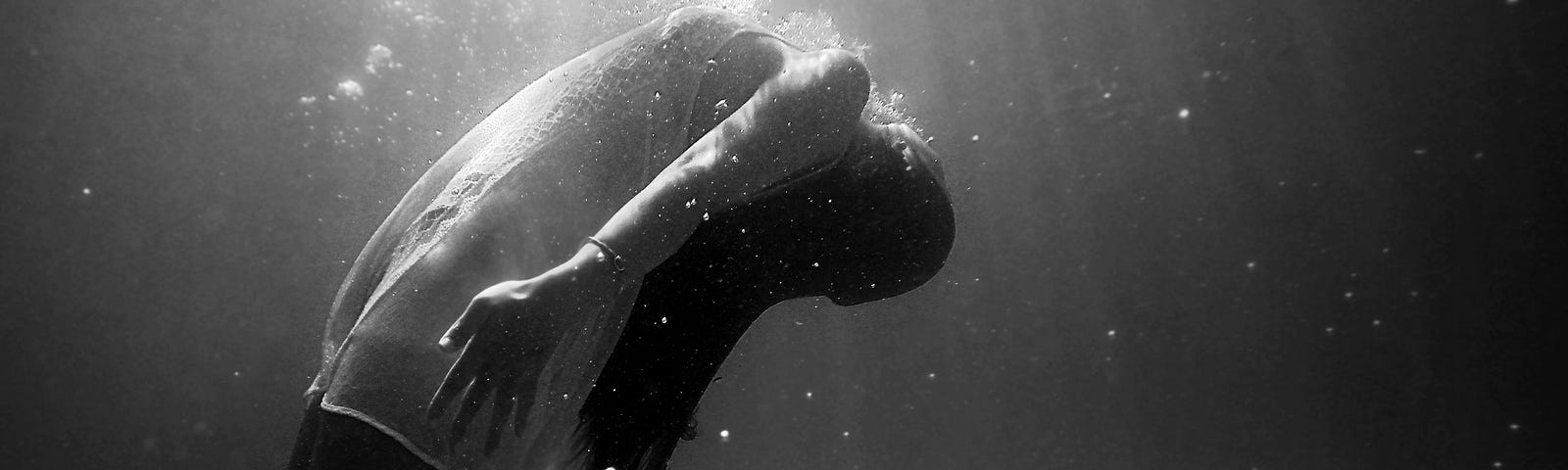 A female in a sheer dress underwater