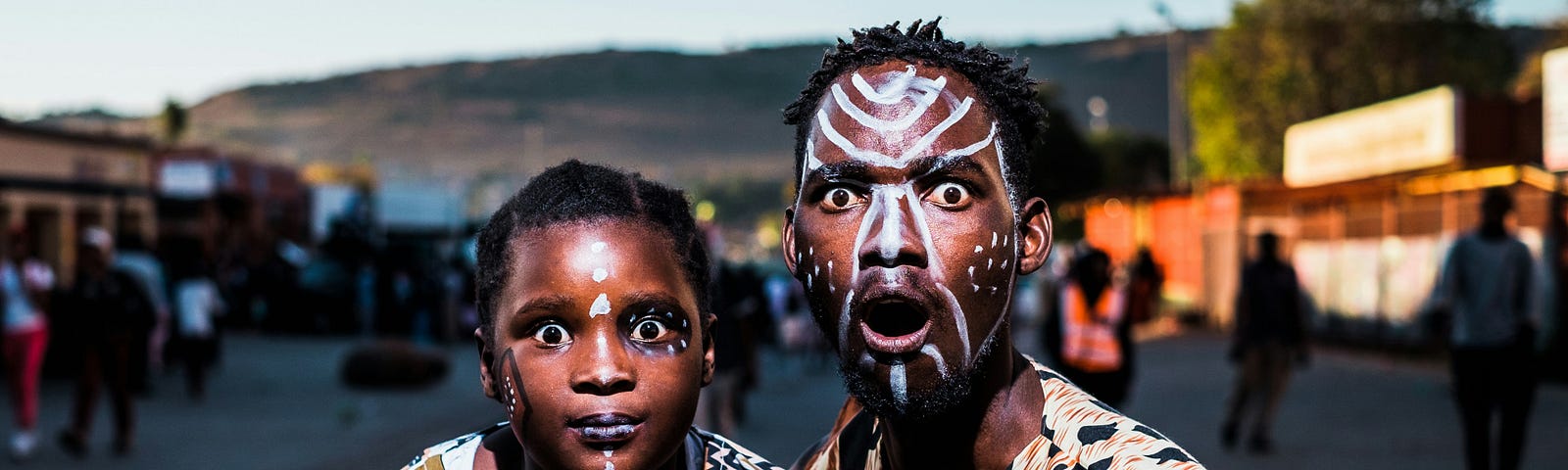 Two aborigines with painted faces stare with amazement.