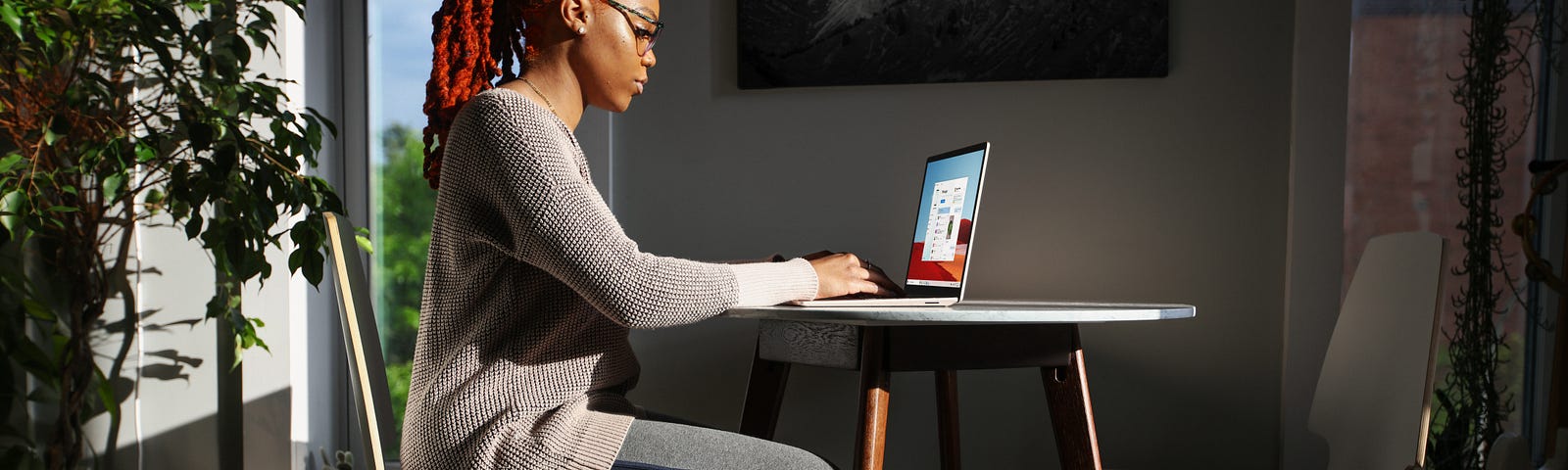 woman typing on laptop computer while sitting at a table