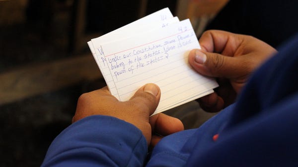 A student practices with flashcards with facts about American government during a class at the public library in Brush, Colo.